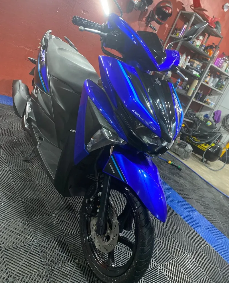 Scooter azul contra a parede vermelha